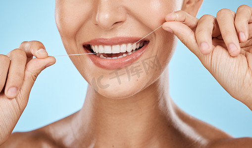 蓝色背景下隔离的女性牙线牙齿缩放、微笑和牙科保健、清新口气和口腔清洁。