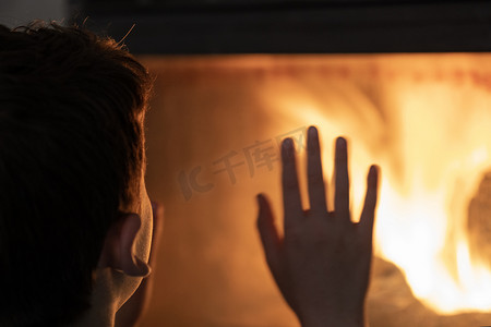 欧洲家庭摄影照片_孩子在家里用火烧木头取暖 - 欧洲能源危机导致停电期间没有电