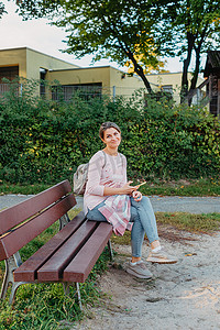 在日落或日出时间从长凳上欣赏城市景观的女孩。