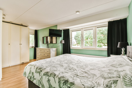 一间有绿色墙壁和一张大床的卧室