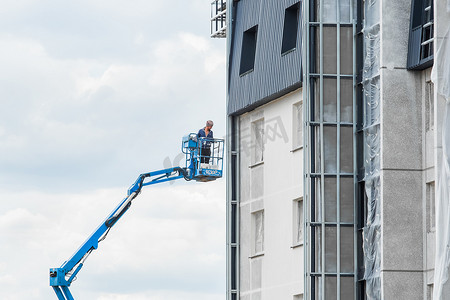 2020新高度摄影照片_白俄罗斯，明斯克 — 2020年5月28日：建筑工地在建房屋新立面附近升降平台上的产业工人