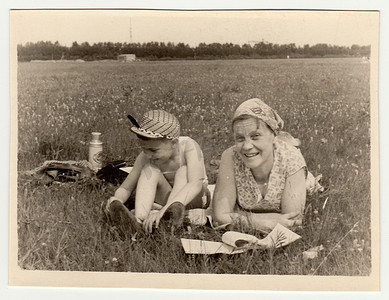 复古照片显示一位母亲带着儿子在草地上休息