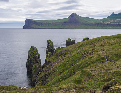 偏远的摄影照片_西峡湾美丽的 Hornbjarg 悬崖风景优美，冰岛偏远的自然保护区 Hornstrandir，大鸟悬崖岩石蓝海和多云的天空背景
