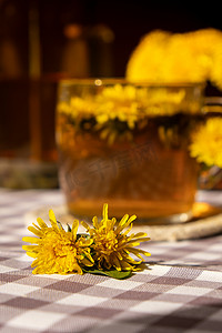 蒲公英花健康茶在玻璃茶壶和玻璃杯在桌上。