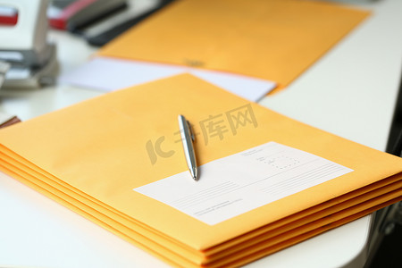 办公室桌面上带笔的商务信函黄色信封