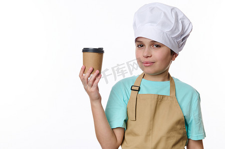 戴着厨师帽和米色围裙的帅气少年，用生态纸杯卖外卖热饮咖啡茶