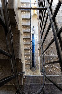 绿色矩形摄影照片_旧废弃建筑中旧矩形螺旋楼梯的顶视图