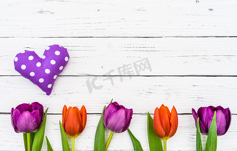 春天郁金香花摄影照片_与心脏和美丽的郁金香花的母亲节背景