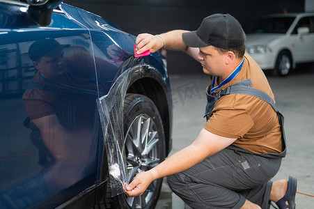 汽车服务中的师傅给车身贴上防护装甲膜。