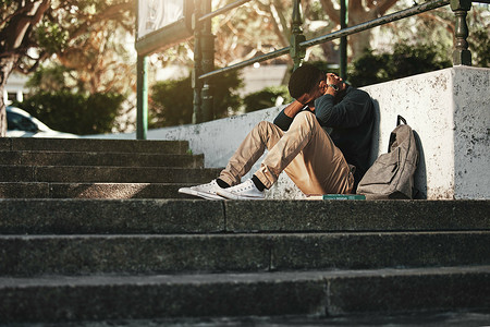悲伤、抑郁和黑人在大学里焦虑，在校园楼梯上因教育而感到压力和头痛。
