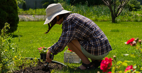 戴草帽的女孩从事园艺工作。