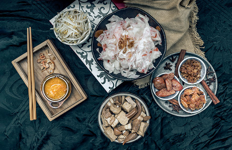 中式食物摄影照片_中式蒸宽米粉配红烧肉、豆腐、甜酱油脆鱿鱼和豆芽、香肠切片、炸虾米和泡菜萝卜配泡椒。