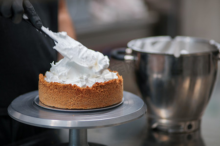 糕点师设计师用抹刀在馅饼皮中填入柠檬味蛋白酥皮慕斯奶酪奶油