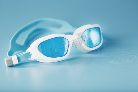 蓝色背景中白色框架中的游泳镜