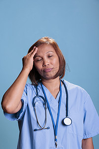 疲惫的护士在从事医学专业工作时患有偏头痛