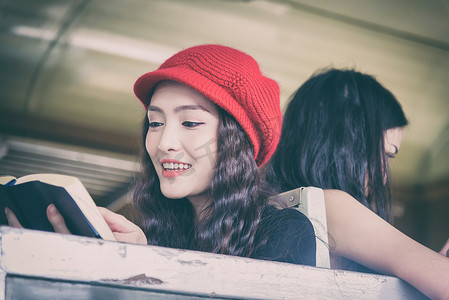 兰芳园丝袜奶茶摄影照片_亚洲女性旅行者在火车上读书和聊天