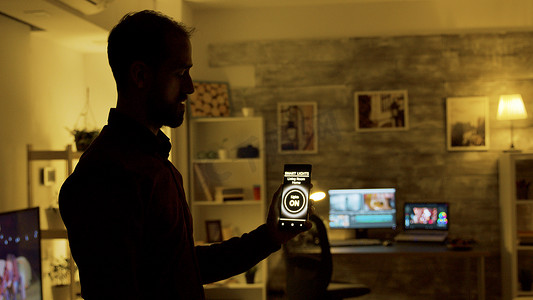 男人使用智能灯应用打开房子里的灯泡