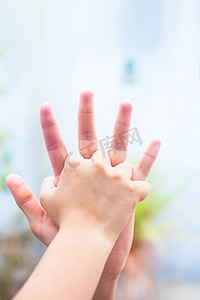 孩子的手将她的手与父亲拍摄的照片进行比较，背景模糊和父亲节（6 月 16 日）的概念。