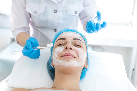 女专业医生美容师在病人脸上敷面膜进行皮肤护理。