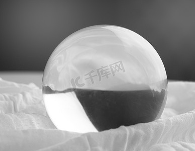 透明灰色背景摄影照片_灰色渐变背景上透明的水晶玻璃球球体