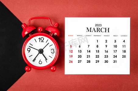 2023 年 3 月日历年，红色和黑色背景上有闹钟。