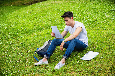 在城市公园学习的年轻男学生