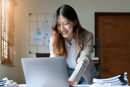 财务、规划、营销和会计，亚洲员工在工作中使用文件和笔记本电脑检查财务报表的肖像