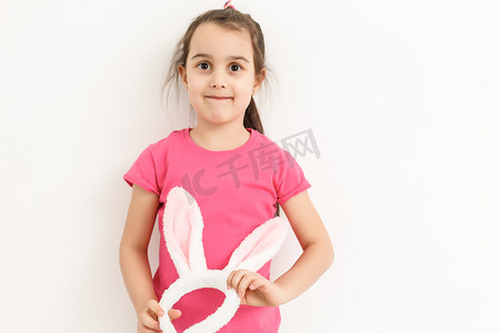 戴着滑稽兔子耳朵的快乐掉牙小女孩