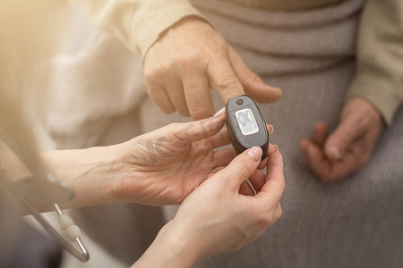 老人和护士测量脉搏血氧计