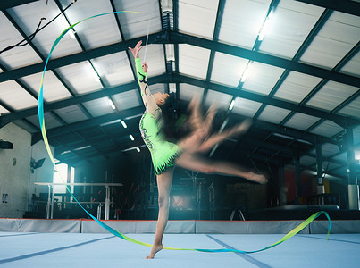 体操、运动模糊和丝带舞与一名女子在奥运会比赛的健身房训练中。