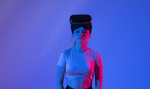 特写年轻女性站在工作室里，戴着 VR 眼镜，在虚拟空间中用手滑动滚动缩放，同时与 metaverse 中的对象交互。