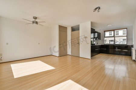 木地板客厅摄影照片_有木地板和厨房的一个空的客厅