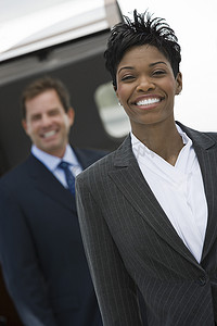 快乐的非洲裔美国女商人与同事在机场背景中的肖像