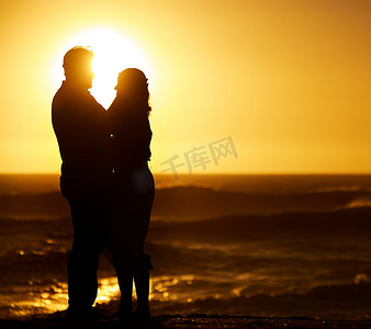 拥抱在日落的成熟夫妇剪影。
