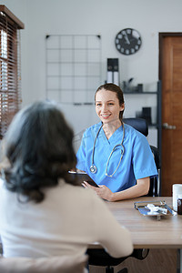 一位女医生手持平板电脑在治疗前讨论和分析患者病情的画像。