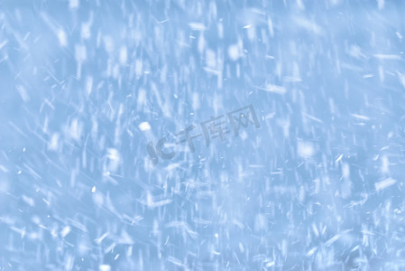 下雪花摄影照片_蓝色背景下飘落的雪花