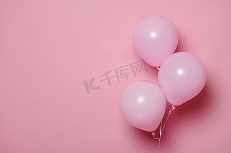 三个粉色柔和的充气球、孤立的粉色背景上的氦气球和免费广告空间