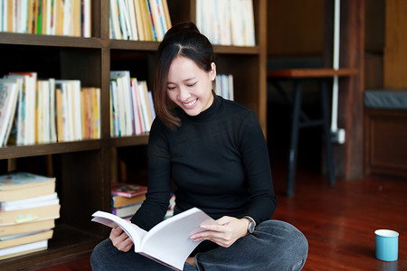 认知的人摄影照片_一张笑脸在图书馆找课本的亚洲年轻女性的画像