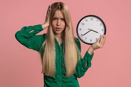 困惑的女人焦虑地按时检查时间、上班迟到、延误、截止日期
