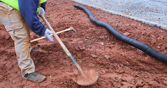 趁着大雨，工人挖沟铺设雨水排水管