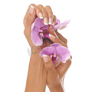 在工作室进行水疗或美容院治疗后，女人的手、美女和兰花上有修指甲。