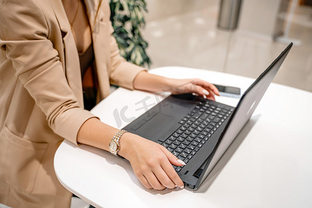 一位女商人坐在咖啡馆里，在电脑前工作。