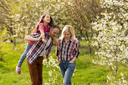 快乐的年轻家庭在绿色大自然中共度时光