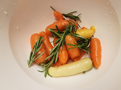 白色容器或碗中的胡萝卜和迷迭香