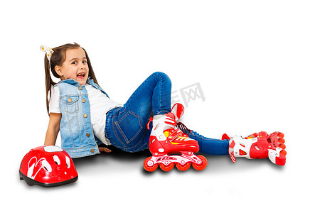 一个可爱的学龄前儿童在学习溜冰时虽然跌倒了，但微笑着。