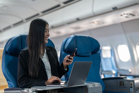 商务女性携带智能手机和笔记本电脑乘飞机旅行的交通、旅游和技术概念