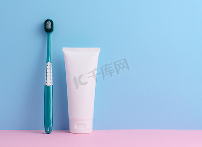蓝色背景中的白色塑料牙膏管和牙刷