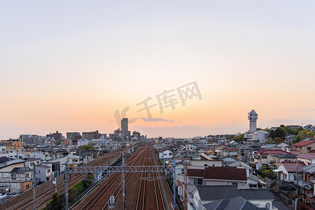 日本明石市 — 2023 年 4 月 19 日：钟楼旁的铁轨日落