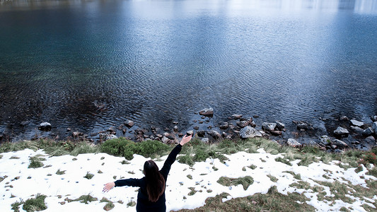 pond摄影照片_快乐的女人在波兰塔特里山 Morskie Oko 雪山小屋附近的 Czarny Staw pod Rysamy 或 Black Pond 湖上享受，无人机景观，波兰扎科帕内。 