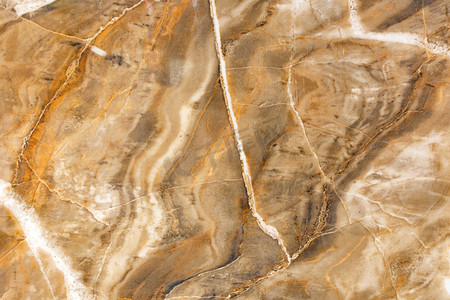 米色和棕色大理石的表面、质地和背景，有裂缝和波浪。